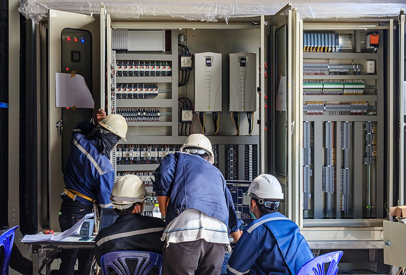 Equipe montando painel elétrico